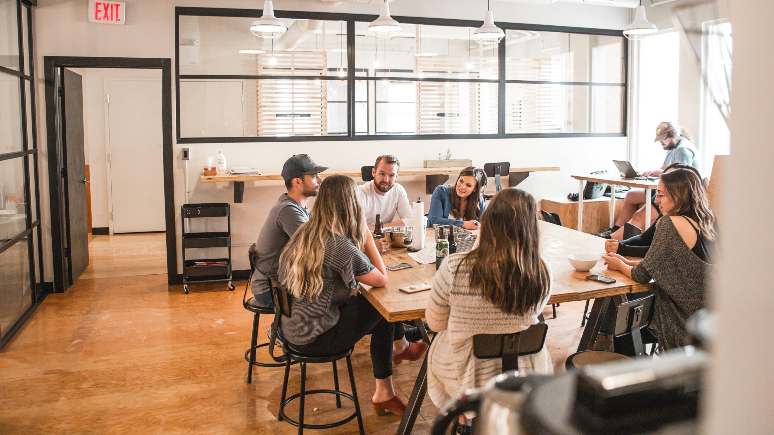 Group of professionals sitting around a desk discussing brand strategy market research solutions and planning actionable insights.