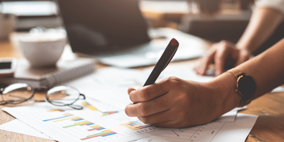 Person writing reports, symbolizing the data-driven insights and strategic analysis provided by brand equity studies.