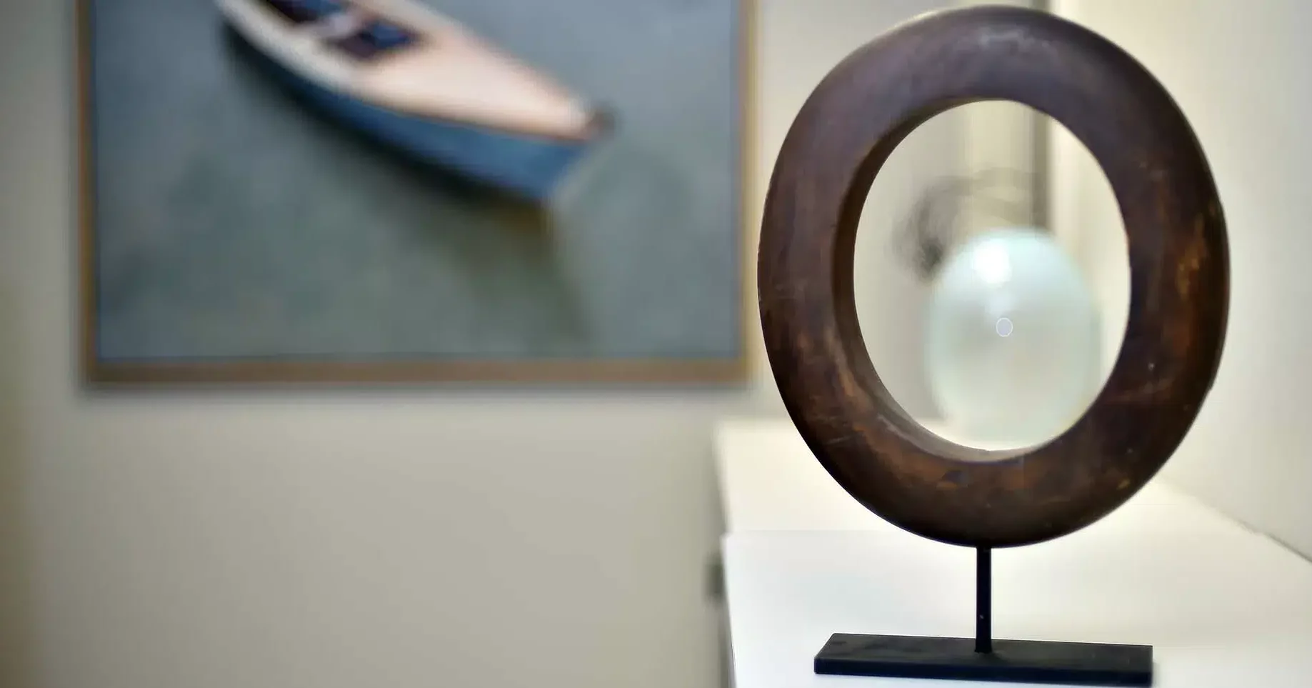 Photo of the Olinger logo elegantly carved into a wooden tabletop statue, displayed in the Olinger office in New Orleans, Louisiana.
