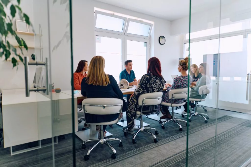A diverse focus group engaged in discussion around a conference table, illustrating a typical market research session.